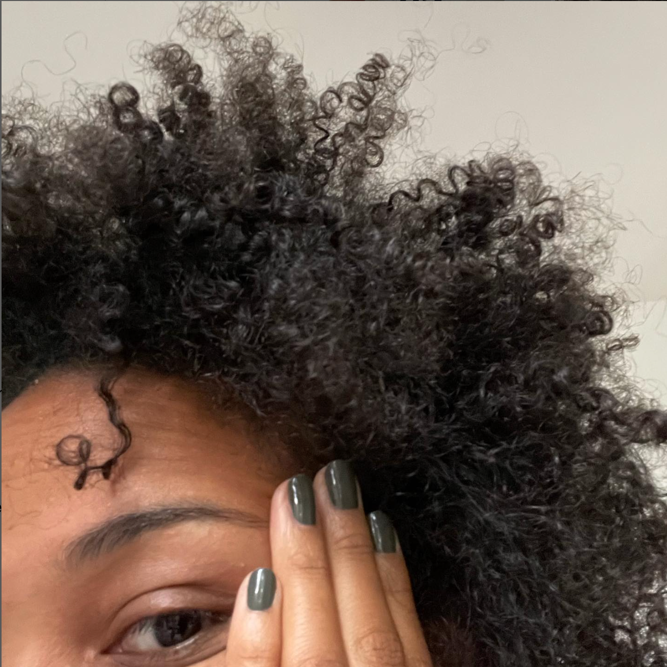 Femme aux cheveux texturés coiffée avec les produits NIIR – routine coiffage naturelle, sans parfum ni silicone, pour des boucles définies et nourries.
