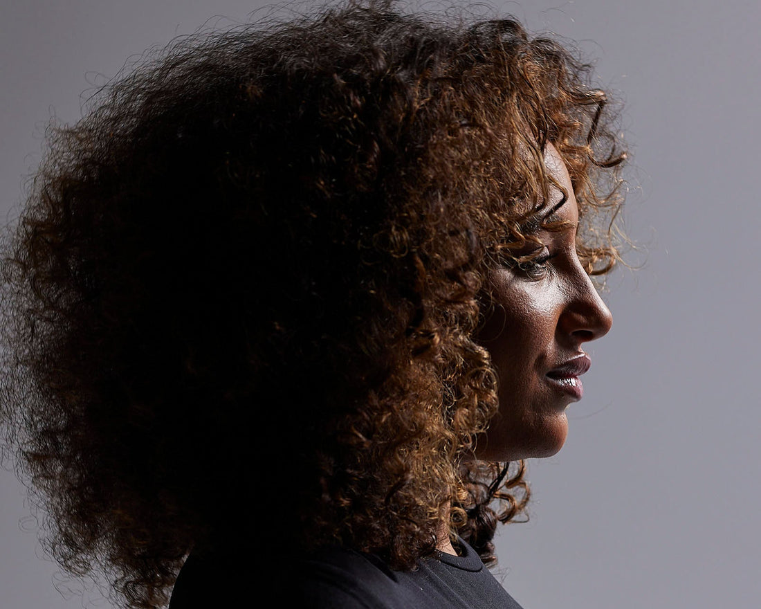 Femme aux cheveux bouclés avec routine naturelle – soin capillaire NIIR pour boucles souples et définies